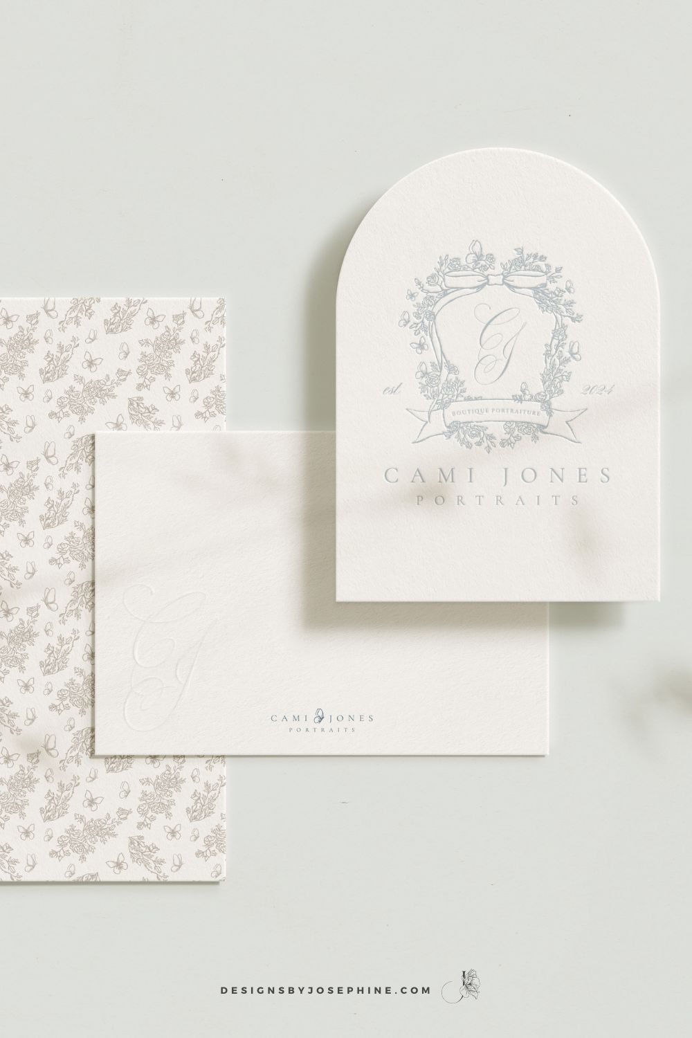 Elegant brand stationery design for Cami Jones Portraits featuring a soft blue floral crest logo, delicate bow illustration, and romantic neutral tones.